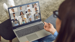 many people attending a virtual meeting on a laptop screen